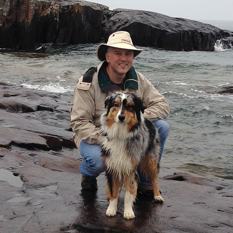 Dr. Kevin Stepaniuk with a dog on the shore