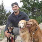 Dr. Zachary Wright with three dogs in the mountains